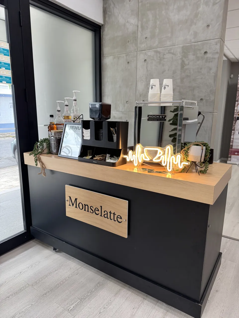 Barra de Monselatte con máquina de café y vasos en un interior